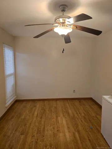 a view of a room with wooden floor fan and window