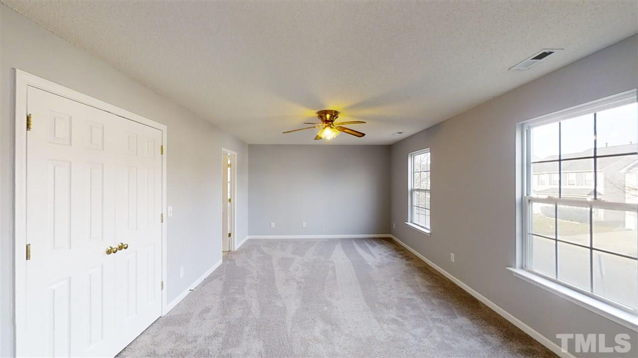 4348 Cardinal Grove Boulevard Raleigh, NC 27616 - Photo 17 of 30 an empty room with windows and chandelier fan