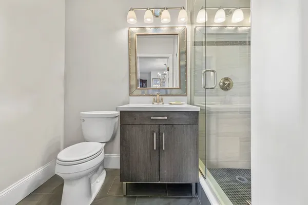 a bathroom with a sink a toilet and shower