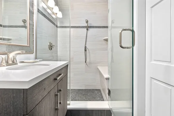a bathroom with a shower sink and mirror