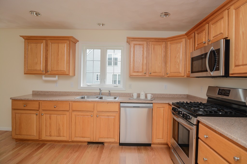 35 Hadleigh Road, Unit 35 Windham, NH 03087 - Photo 14 of 39 a kitchen with stainless steel appliances granite countertop a stove a sink and a microwave