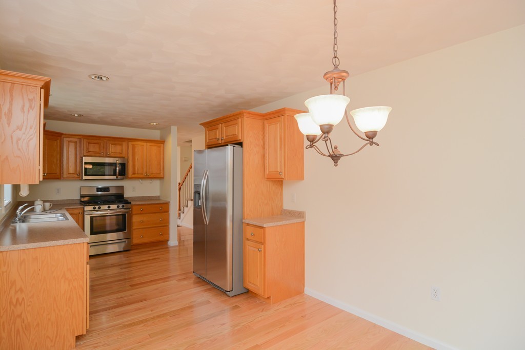 35 Hadleigh Road, Unit 35 Windham, NH 03087 - Photo 16 of 39 a kitchen with stainless steel appliances granite countertop a refrigerator a stove top oven a sink dishwasher and wooden floor
