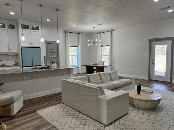 a living room with furniture and a wooden floor