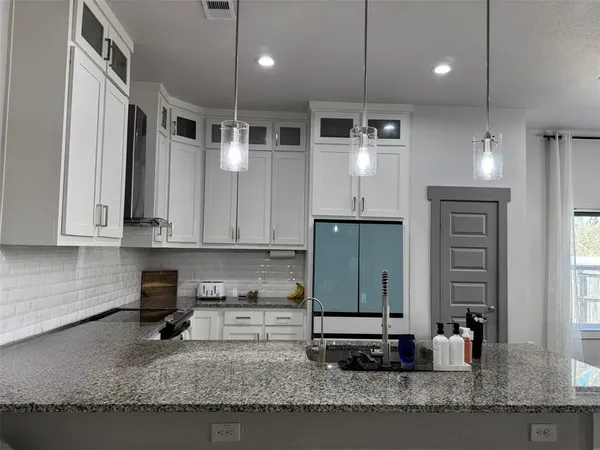 a kitchen with stainless steel appliances granite countertop a sink a stove and a refrigerator