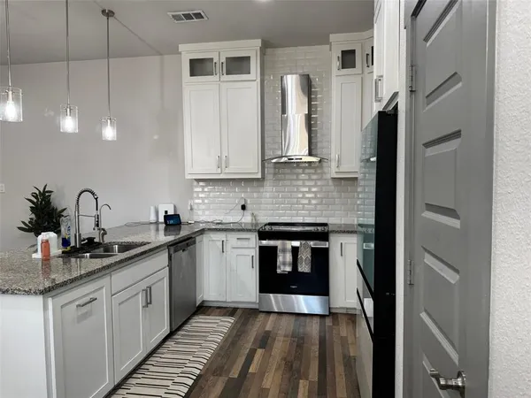 a kitchen with stainless steel appliances a sink stove and refrigerator