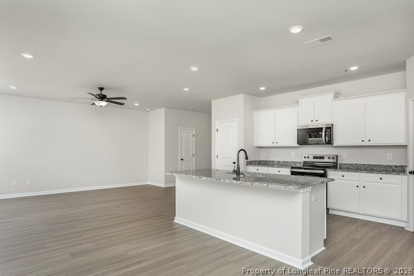 28 Rider Street Broadway, NC 27505 - Photo 10 of 22 a kitchen with stainless steel appliances granite countertop a sink a stove and a refrigerator