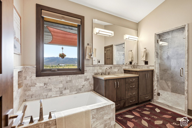 1130 Pace Road Park City, UT 84098 - Photo 38 of 73 Built-in soaking tub, wood-finish window trim, stone-tiled walls, dual vanity with undermount sinks, and a glass-enclosed shower