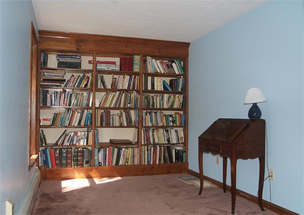 89 Scribner Road Tyngsborough, MA 01879 - Photo 18 of 30 a living room with a book shelf and a book shelf