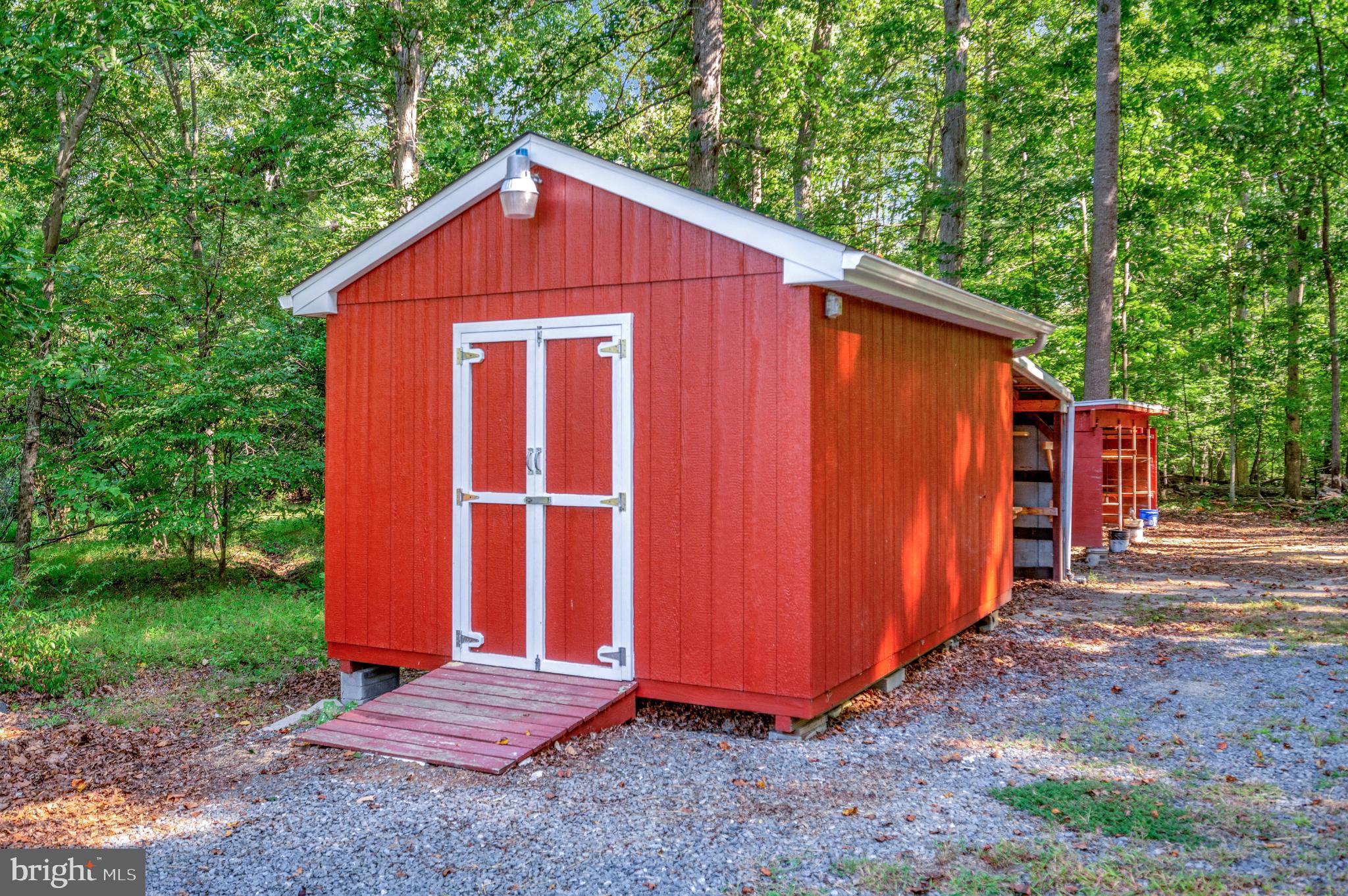 8625 Brock Road Spotsylvania, VA 22553 - Photo 36 of 47 Charming red shed nestled in lush greenery.