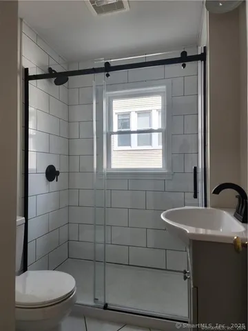 a bathroom with a sink a toilet and shower