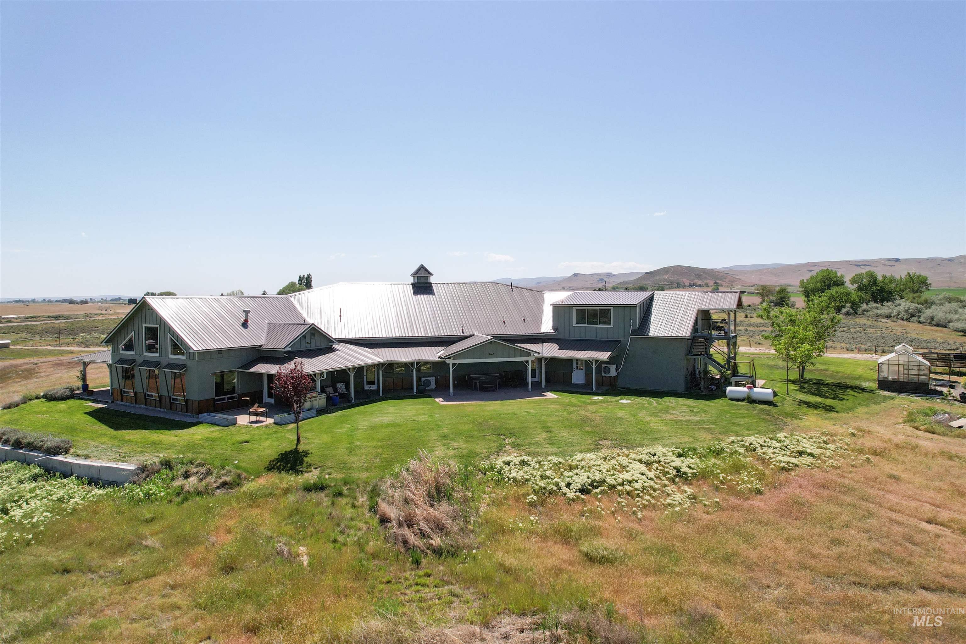 1030 Desert Glen Road Adrian, OR 97901 - Photo 9 of 47 Expansive property featuring a multi-gable roofline, a large covered porch, and a dedicated greenhouse structure