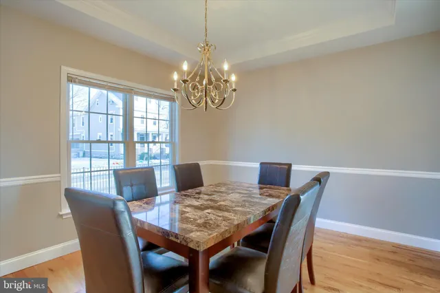 a view of a dining room with furniture a chandelier and wooden floor