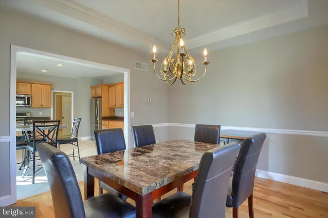 a view of a dining room with furniture wooden floor and chandelier