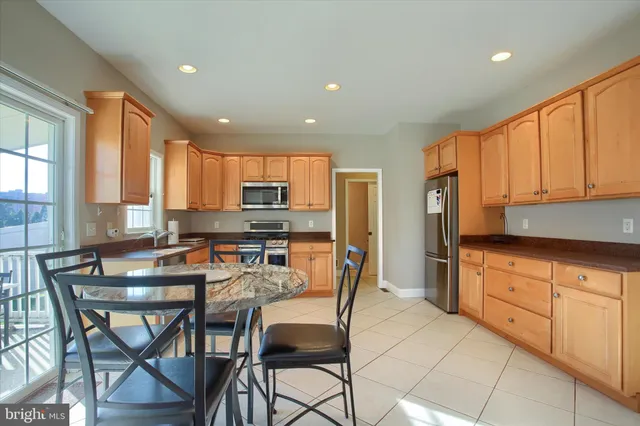 a kitchen with stainless steel appliances a table and chairs in it