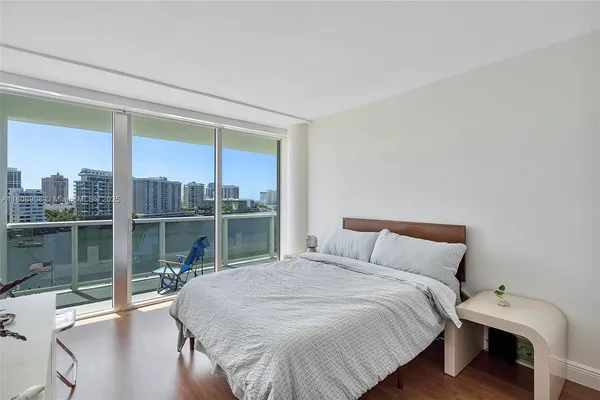 a bedroom with a bed and a large window