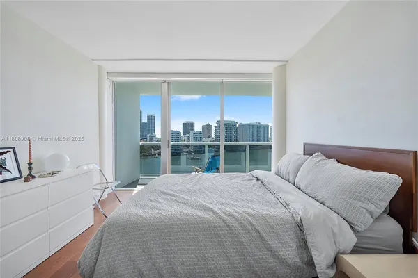 a bedroom with a bed and a large window
