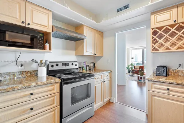 a kitchen with stainless steel appliances white cabinets and a stove top oven