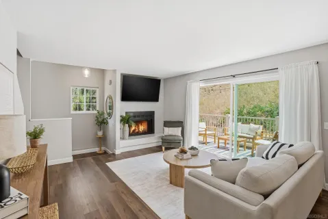 a living room with furniture a fireplace and a floor to ceiling window