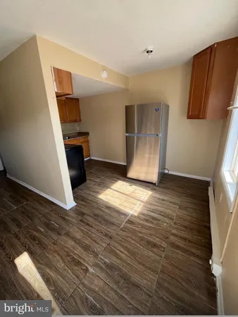 a view of a kitchen with wooden floor and a refrigerator
