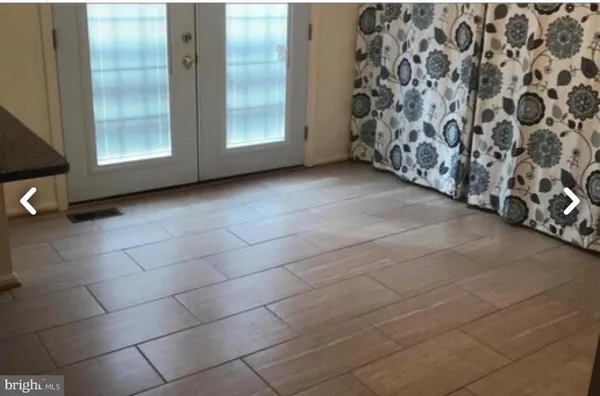 a view of a kitchen with wooden floor and electronic appliances