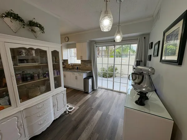 a view of a kitchen with fridge and wooden floor