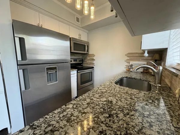 a kitchen with kitchen island a refrigerator stove and microwave