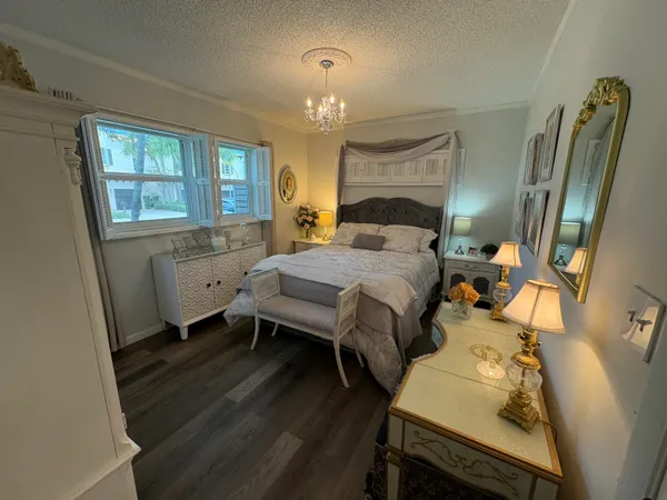 a bedroom with a bed and a chandelier