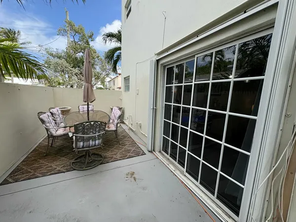 a view of a porch with table and chairs and potted plants