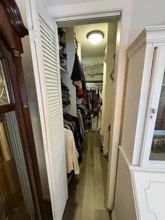 a view of walk in closet with clothes and shoes