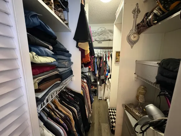 a view of walk in closet with clothes and shoes
