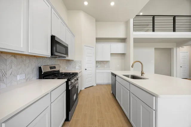 a kitchen with stainless steel appliances a sink stove and cabinets