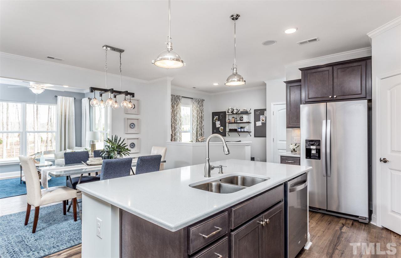 1720 Highpoint Street, Unit HV 264 Wake Forest, NC 27587 - Photo 11 of 20 a kitchen with stainless steel appliances a sink a refrigerator a table and chairs