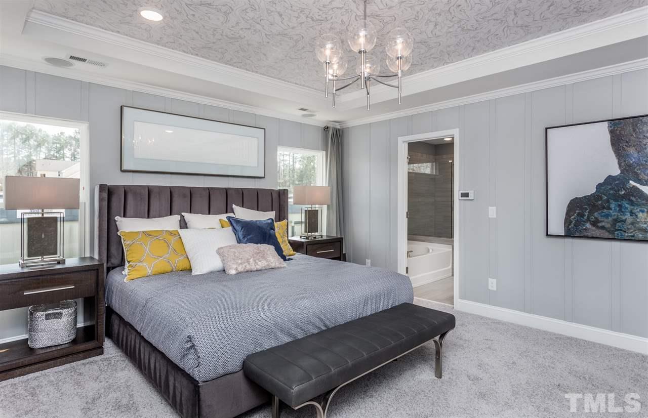 1720 Highpoint Street, Unit HV 264 Wake Forest, NC 27587 - Photo 18 of 20 a bedroom with a bed chandelier painting on the wall and a window