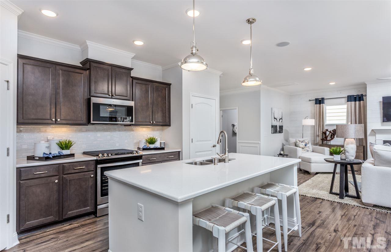 1720 Highpoint Street, Unit HV 264 Wake Forest, NC 27587 - Photo 9 of 20 a kitchen with a sink a stove a refrigerator and chairs