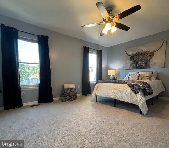 a bed sitting in a bedroom next to a window