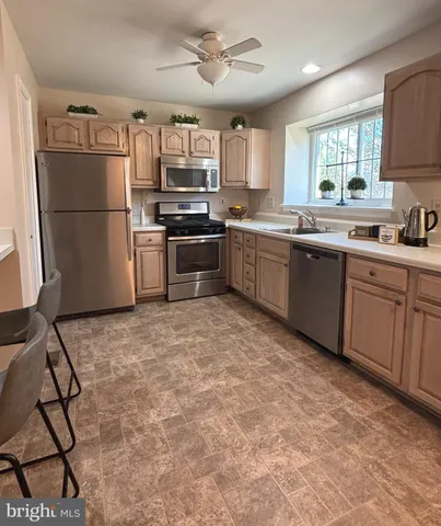 a kitchen with granite countertop a refrigerator stove top oven and sink