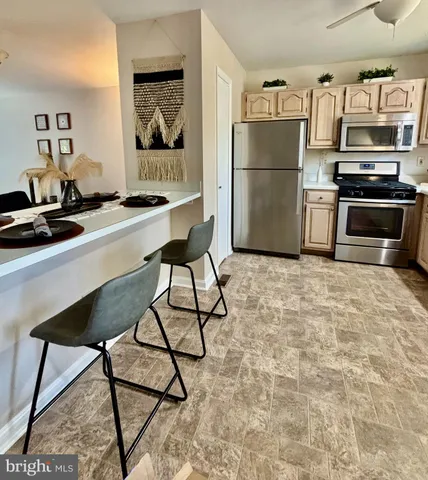 a kitchen with a refrigerator and a stove top oven