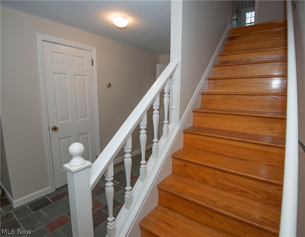 large formal foyer with classic slate tile floor and hall coat closest.