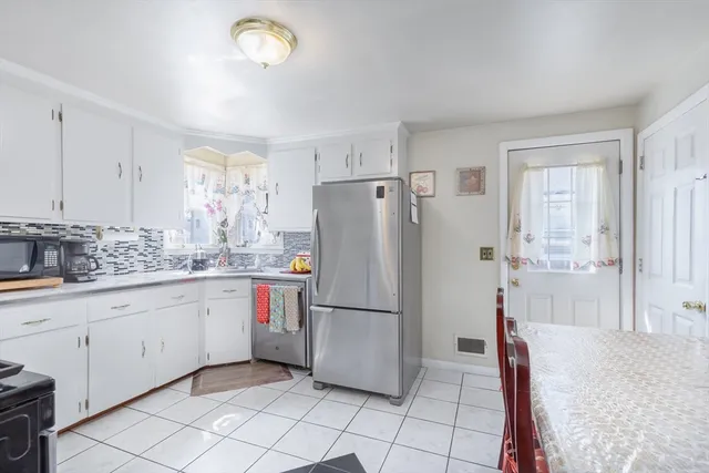 a kitchen with a refrigerator a sink and cabinets