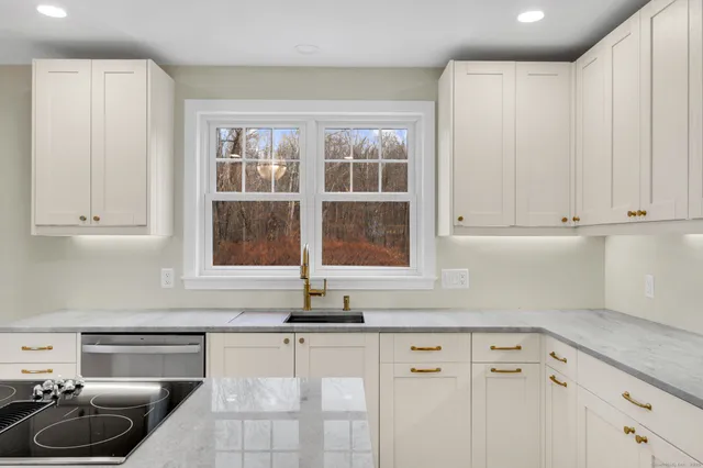 a kitchen with granite countertop a sink and cabinets