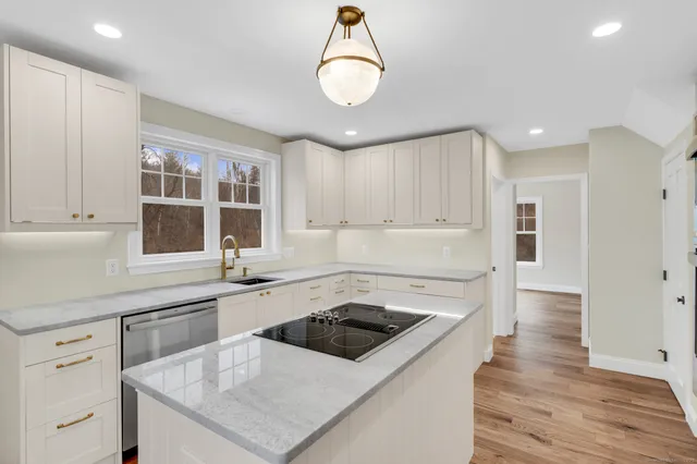 a kitchen with a stove sink and cabinets