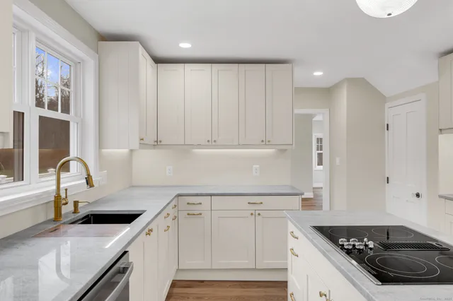 a kitchen with a sink stove top oven and cabinets