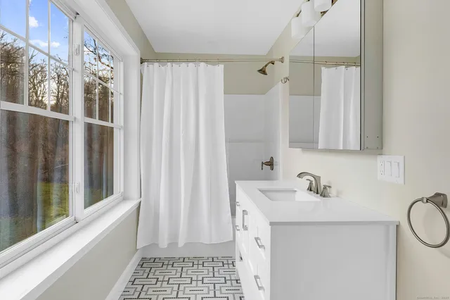 a bathroom with a sink a mirror and a shower