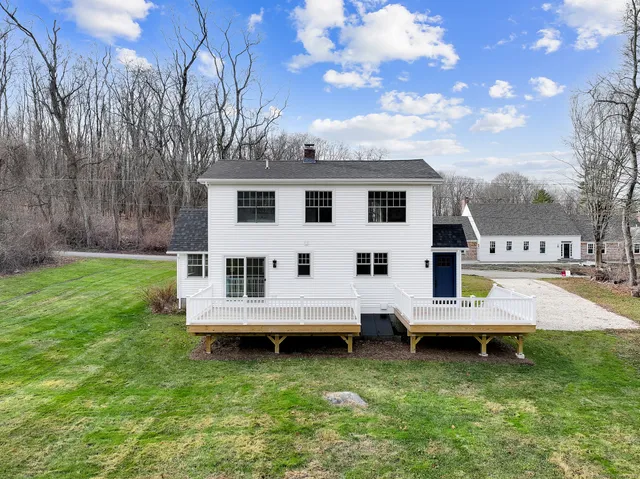 a view of a house with backyard and sitting area