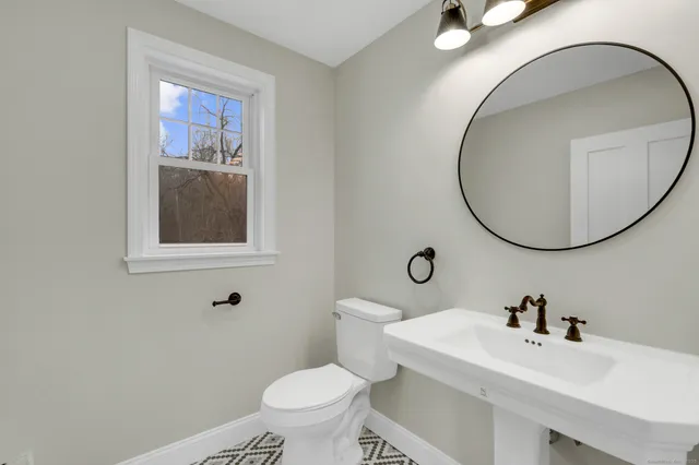 a bathroom with a sink mirror and toilet