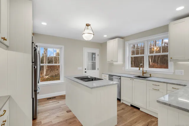 a kitchen with granite countertop cabinets a sink a window and stainless steel appliances