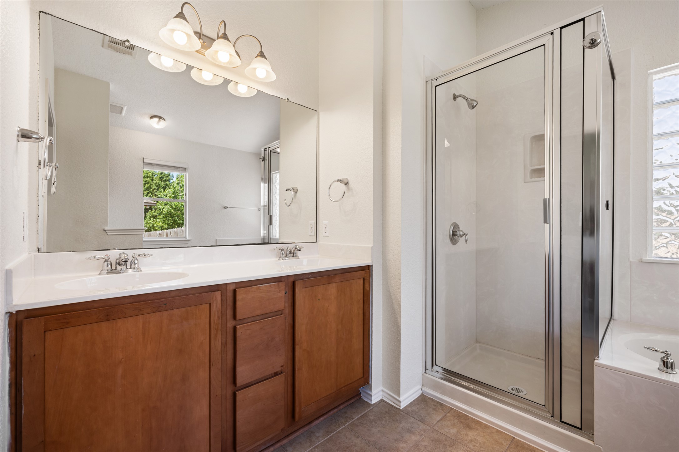 14316 Marathon Road Austin, TX 78717 - Photo 15 of 40 Clean lines define this bathroom featuring a dual sink vanity, walk-in shower, and tile flooring.