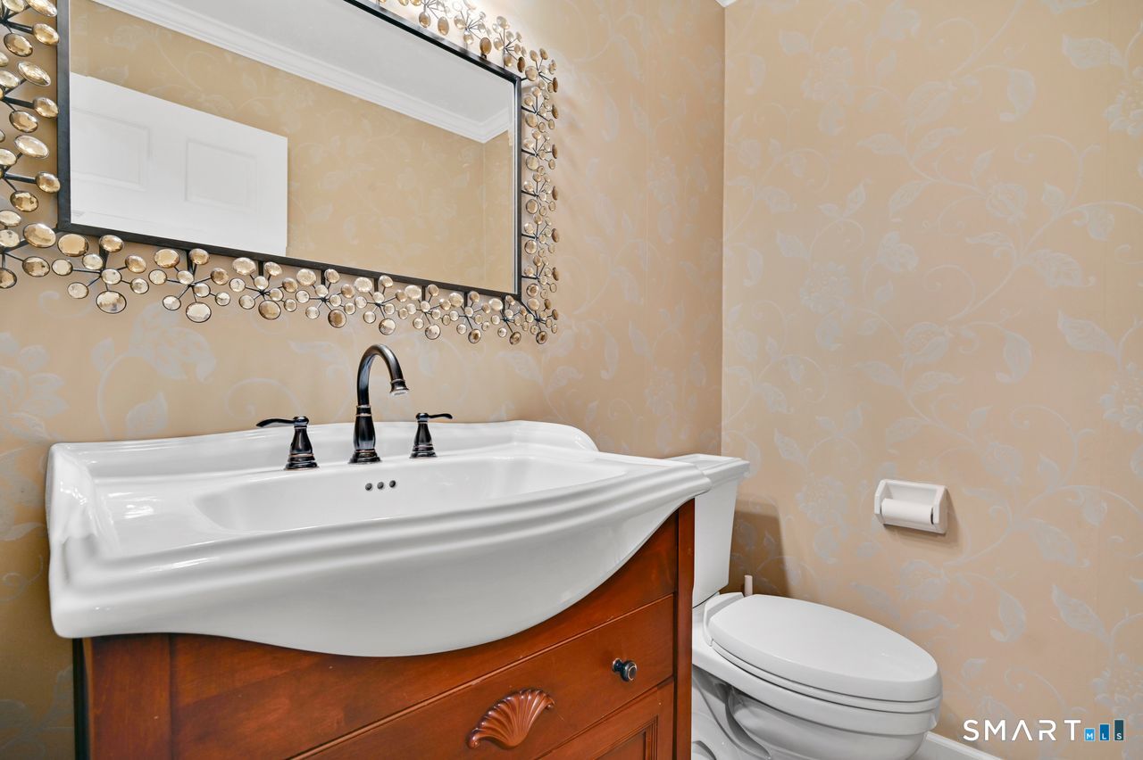 104 Old Farms Road Glastonbury, CT 06073 - Photo 15 of 40 a bathroom with a sink a toilet and mirror