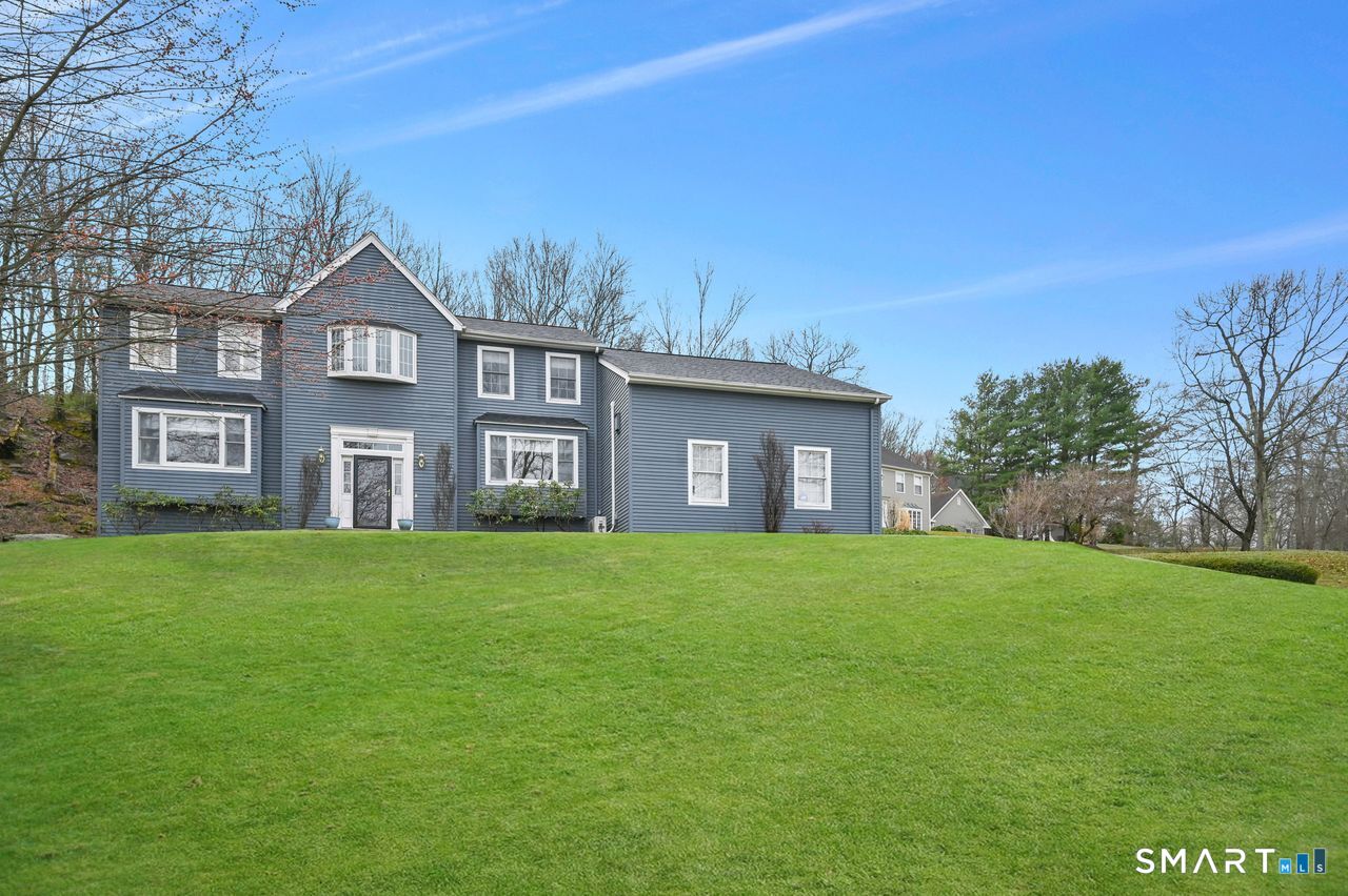 104 Old Farms Road Glastonbury, CT 06073 - Photo 2 of 40 a brick house with a big yard and large trees
