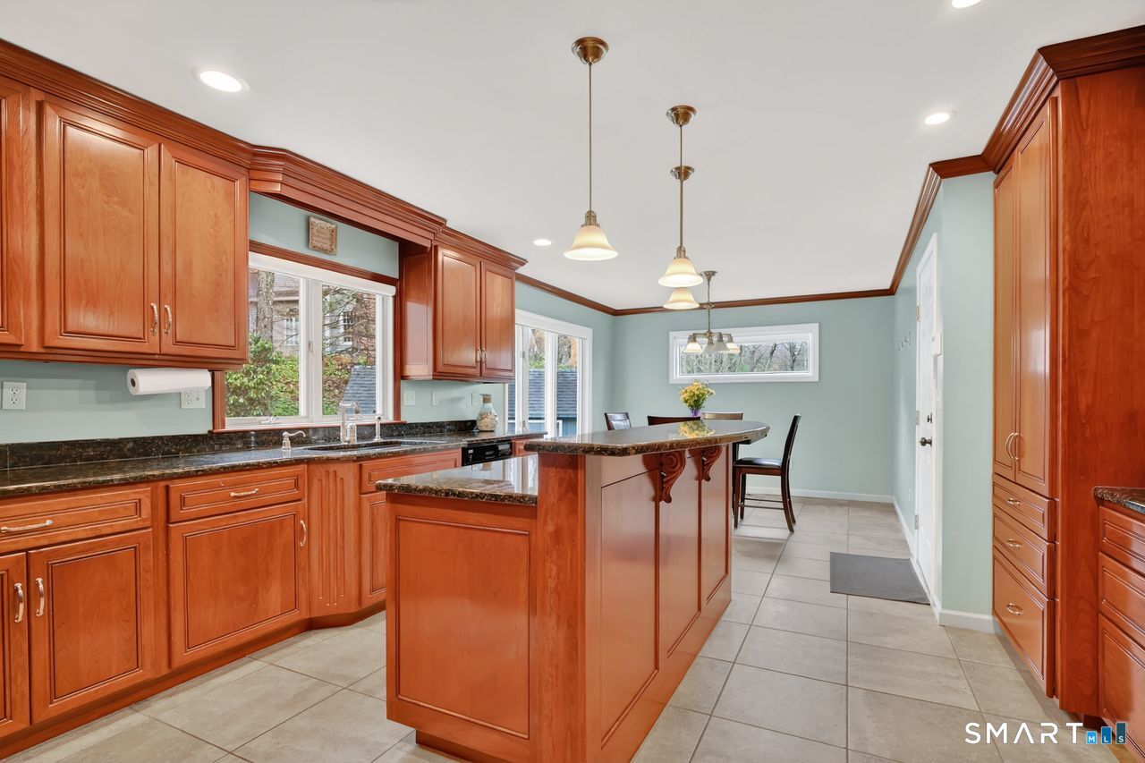 104 Old Farms Road Glastonbury, CT 06073 - Photo 5 of 40 a large kitchen with kitchen island a large counter top space a sink stainless steel appliances and cabinets